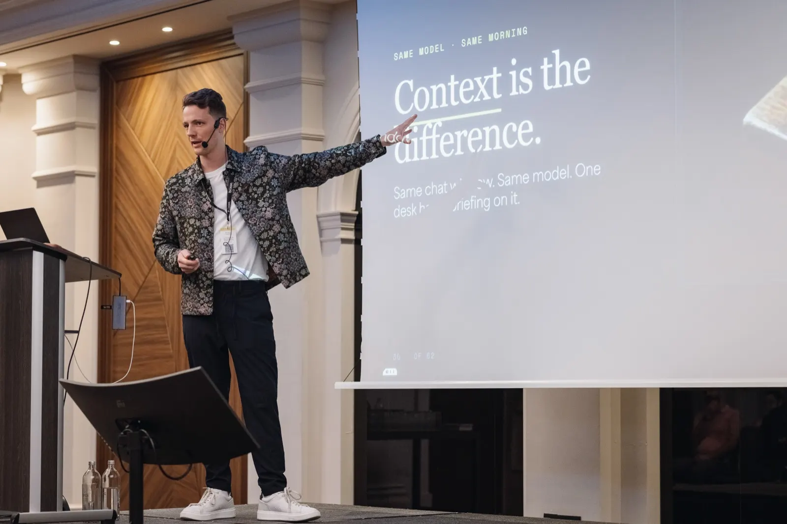 Christoph Sauerborn on stage, pointing at a slide reading “Context is the difference”.