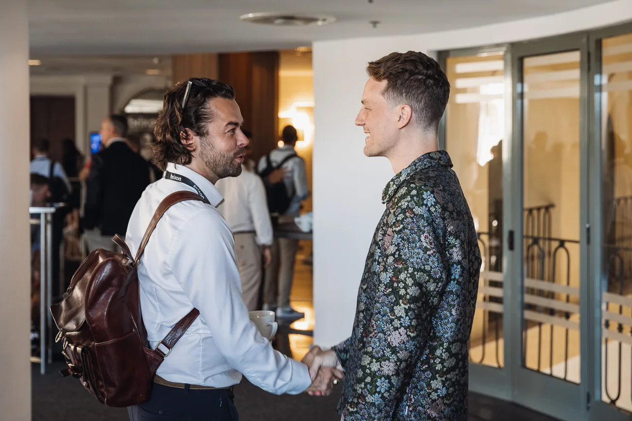 Christoph Sauerborn greeting an attendee at an event.